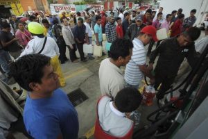 People wait in line to fill containers with gasoline at a gas station in Oaxaca, Mexico. PHOTO: REUTERS/Jorge Luis Plata